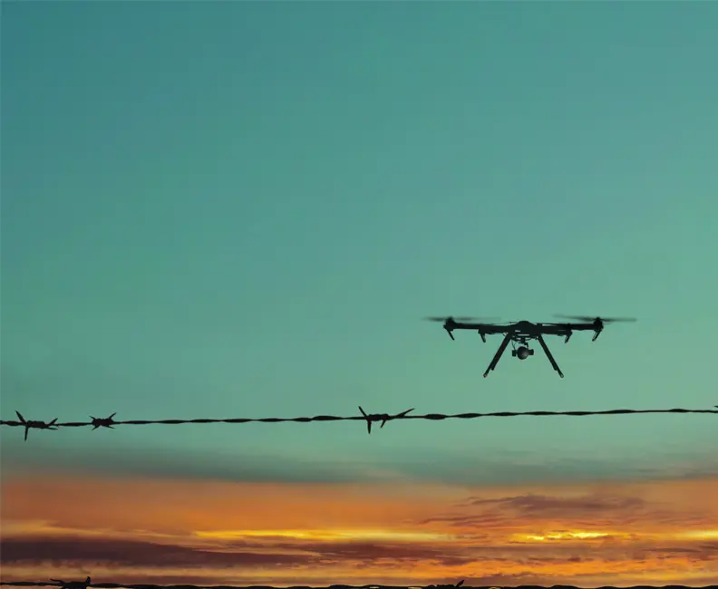 drone flying over a security fence