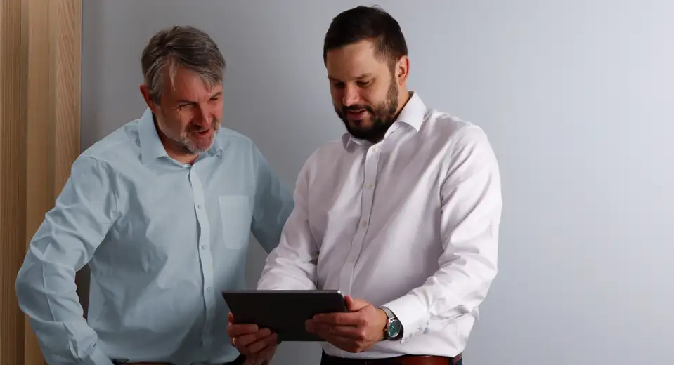 Contact Plextek | Employees check their contact emails on a tablet